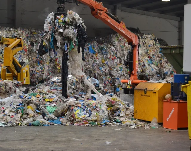 Grappin industriel manipulant des balles de déchets plastiques